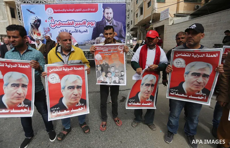 Palestinians hold placards during a protest to show solidarity with Palestinian prisoners held in Israeli Jails, in front of Red cross office in Gaza city, on April 17, 2017. Photo by Mohammed Asad