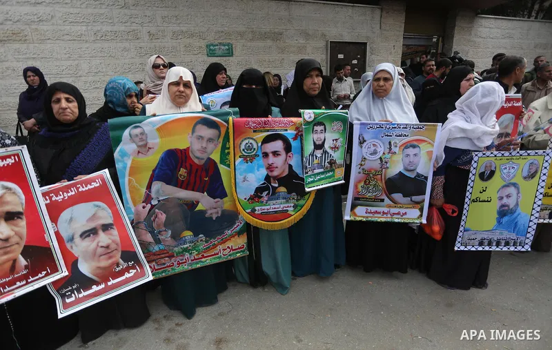 Palestinians hold placards during a protest to show solidarity with Palestinian prisoners held in Israeli Jails, in front of Red cross office in Gaza city, on April 17, 2017. Photo by Mohammed Asad