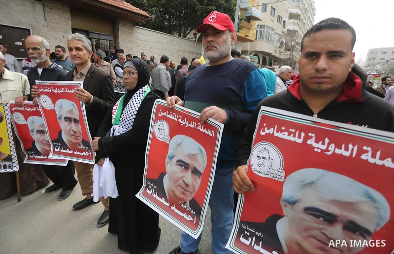 Palestinians hold placards during a protest to show solidarity with Palestinian prisoners held in Israeli Jails, in front of Red cross office in Gaza city, on April 17, 2017. Photo by Mohammed Asad