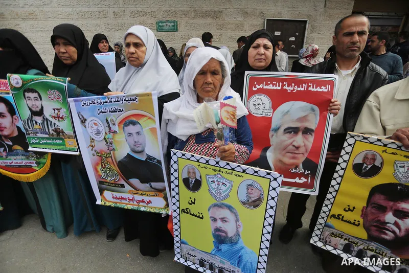 Palestinians hold placards during a protest to show solidarity with Palestinian prisoners held in Israeli Jails, in front of Red cross office in Gaza city, on April 17, 2017. Photo by Mohammed Asad