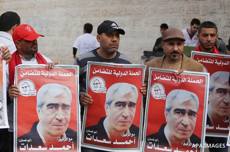 Palestinians hold placards during a protest to show solidarity with Palestinian prisoners held in Israeli Jails, in front of Red cross office in Gaza city, on April 17, 2017. Photo by Mohammed Asad