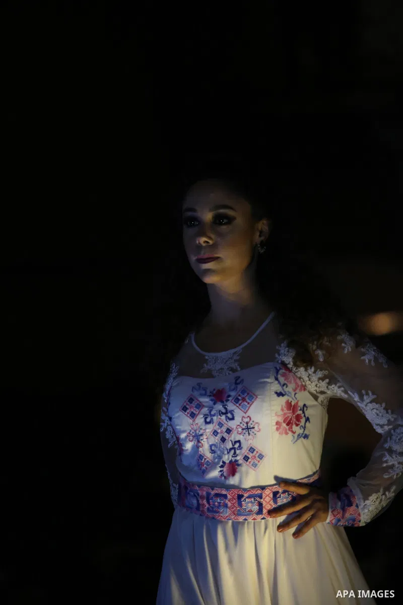 A picture taken on April 15, 2017 shows a Palestinian model displays a traditional Palestinian dress during a fashion show during the 2nd Nablus Festival for Culture and Arts, in the West Bank city of Nablus. The interna...