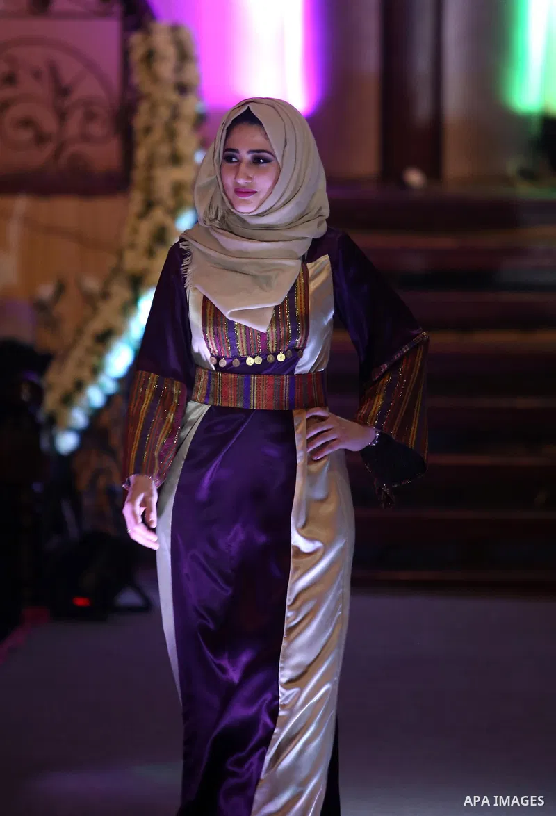 A picture taken on April 15, 2017 shows a Palestinian model displays a traditional Palestinian dress during a fashion show during the 2nd Nablus Festival for Culture and Arts, in the West Bank city of Nablus. The interna...