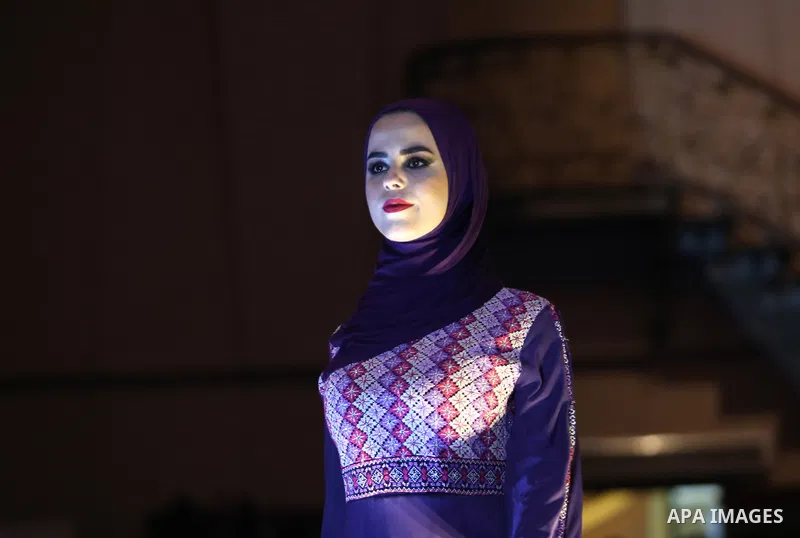 A picture taken on April 15, 2017 shows a Palestinian model displays a traditional Palestinian dress during a fashion show during the 2nd Nablus Festival for Culture and Arts, in the West Bank city of Nablus. The interna...