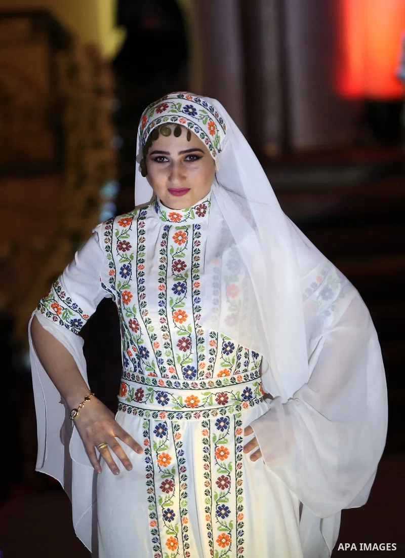 A picture taken on April 15, 2017 shows a Palestinian model displays a traditional Palestinian dress during a fashion show during the 2nd Nablus Festival for Culture and Arts, in the West Bank city of Nablus. The interna...