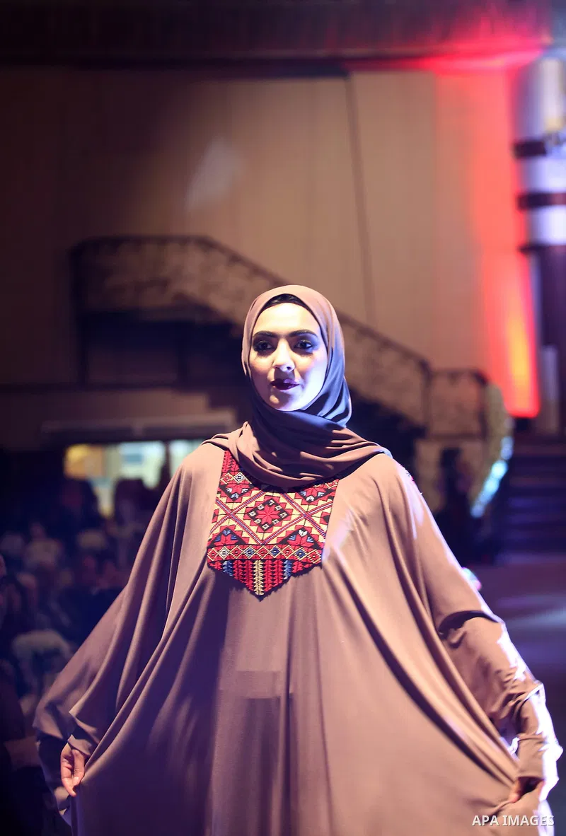 A picture taken on April 15, 2017 shows a Palestinian model displays a traditional Palestinian dress during a fashion show during the 2nd Nablus Festival for Culture and Arts, in the West Bank city of Nablus. The interna...