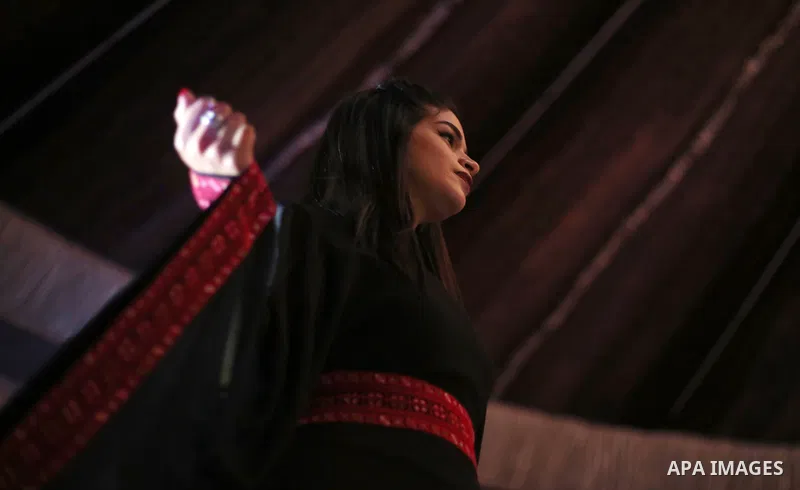 A picture taken on April 15, 2017 shows a Palestinian model displays a traditional Palestinian dress during a fashion show during the 2nd Nablus Festival for Culture and Arts, in the West Bank city of Nablus. The interna...