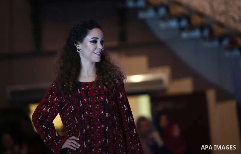 A picture taken on April 15, 2017 shows a Palestinian model displays a traditional Palestinian dress during a fashion show during the 2nd Nablus Festival for Culture and Arts, in the West Bank city of Nablus. The interna...