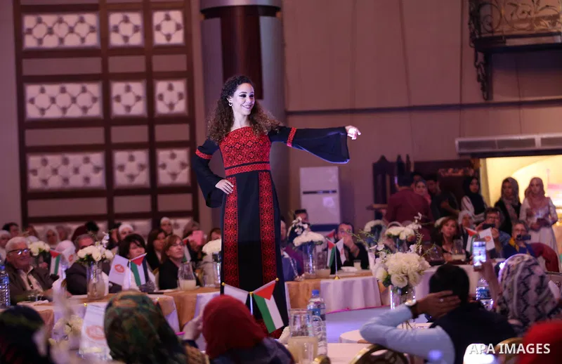 A picture taken on April 15, 2017 shows a Palestinian model displays a traditional Palestinian dress during a fashion show during the 2nd Nablus Festival for Culture and Arts, in the West Bank city of Nablus. The interna...