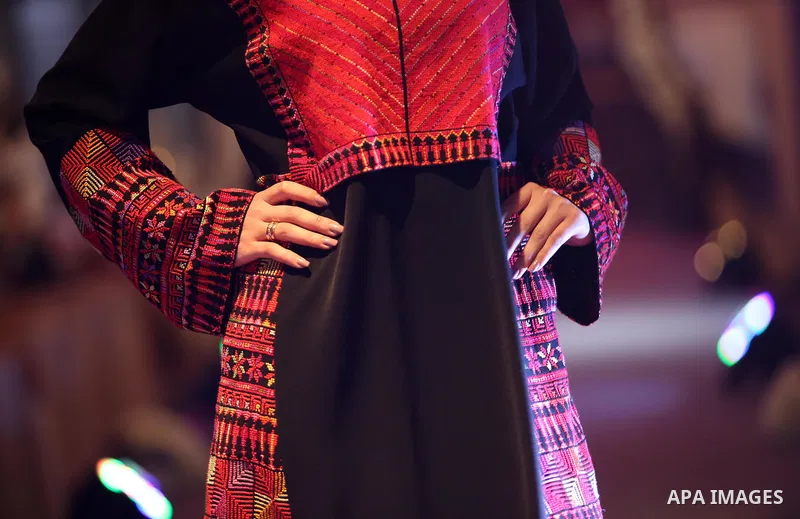 A picture taken on April 15, 2017 shows a Palestinian model displays a traditional Palestinian dress during a fashion show during the 2nd Nablus Festival for Culture and Arts, in the West Bank city of Nablus. The interna...