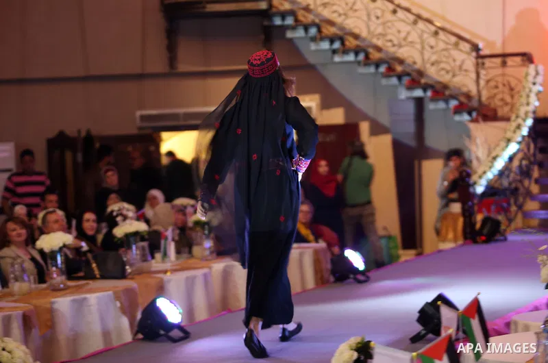 A picture taken on April 15, 2017 shows a Palestinian model displays a traditional Palestinian dress during a fashion show during the 2nd Nablus Festival for Culture and Arts, in the West Bank city of Nablus. The interna...