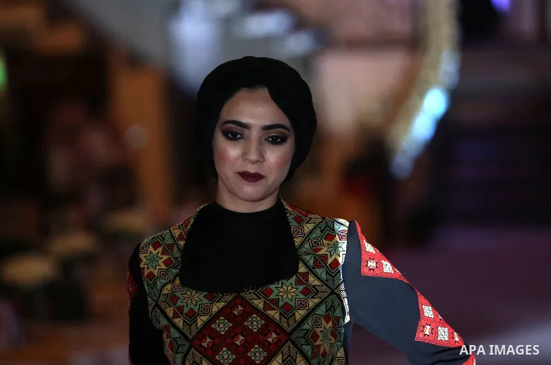 A picture taken on April 15, 2017 shows a Palestinian model displays a traditional Palestinian dress during a fashion show during the 2nd Nablus Festival for Culture and Arts, in the West Bank city of Nablus. The interna...