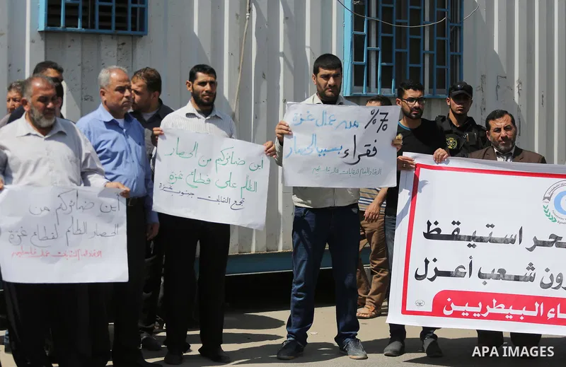 Union of the Palestinian syndicates members hold banners during a protest against Israeli blockade, in Gaza city, on April 19, 2017. Photo by Mohammed Asad
