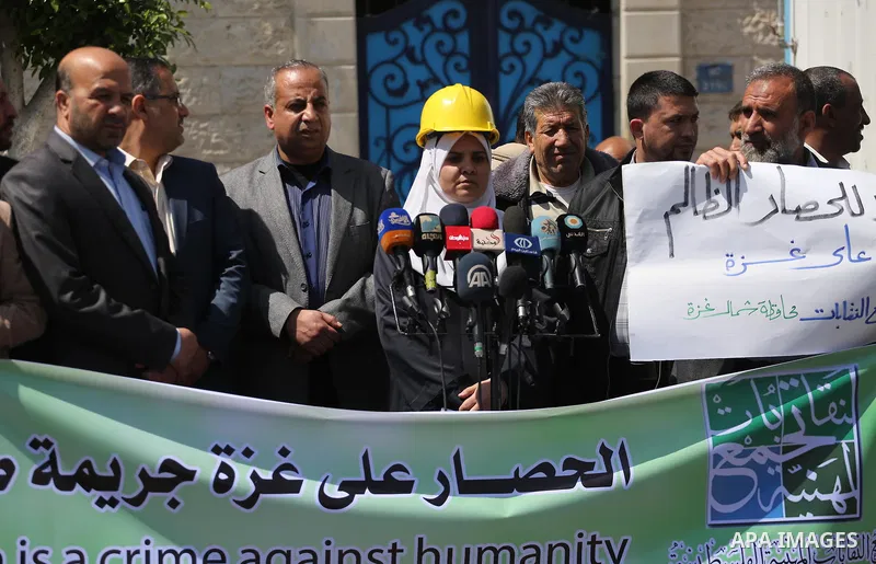 Union of the Palestinian syndicates members hold banners during a protest against Israeli blockade, in Gaza city, on April 19, 2017. Photo by Mohammed Asad
