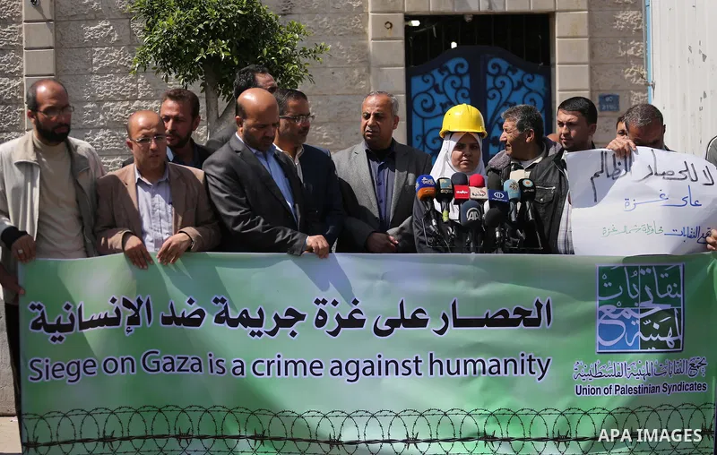 Union of the Palestinian syndicates members hold banners during a protest against Israeli blockade, in Gaza city, on April 19, 2017. Photo by Mohammed Asad