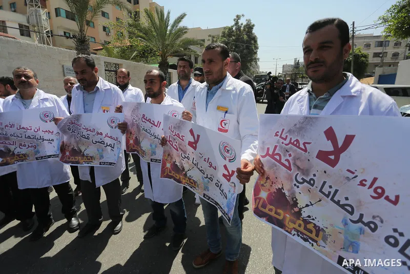 Union of the Palestinian syndicates members hold banners during a protest against Israeli blockade, in Gaza city, on April 19, 2017. Photo by Mohammed Asad