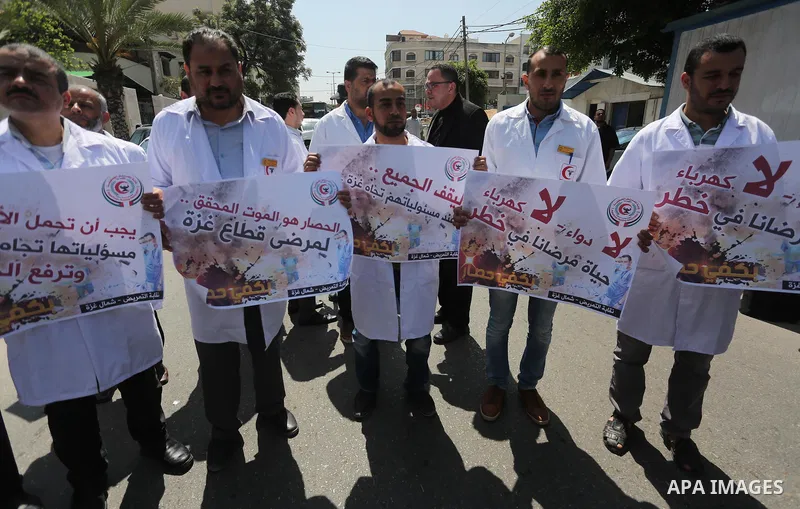 Union of the Palestinian syndicates members hold banners during a protest against Israeli blockade, in Gaza city, on April 19, 2017. Photo by Mohammed Asad