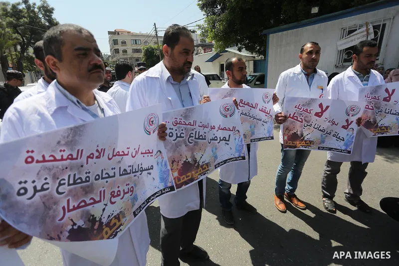 Union of the Palestinian syndicates members hold banners during a protest against Israeli blockade, in Gaza city, on April 19, 2017. Photo by Mohammed Asad