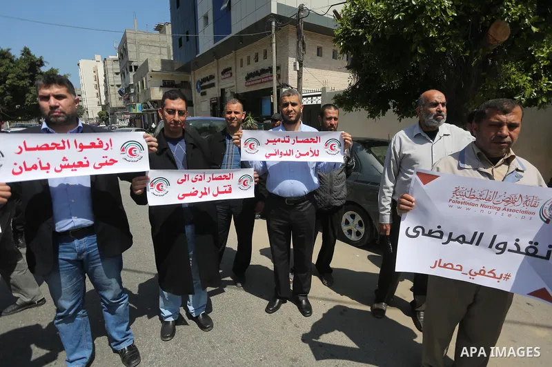 Union of the Palestinian syndicates members hold banners during a protest against Israeli blockade, in Gaza city, on April 19, 2017. Photo by Mohammed Asad