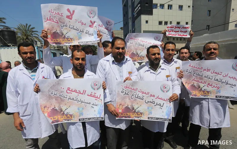 Union of the Palestinian syndicates members hold banners during a protest against Israeli blockade, in Gaza city, on April 19, 2017. Photo by Mohammed Asad