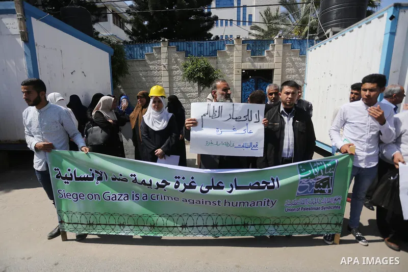 Union of the Palestinian syndicates members hold banners during a protest against Israeli blockade, in Gaza city, on April 19, 2017. Photo by Mohammed Asad