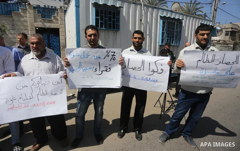 Union of the Palestinian syndicates members hold banners during a protest against Israeli blockade, in Gaza city, on April 19, 2017. Photo by Mohammed Asad