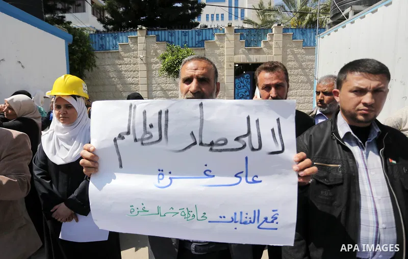 Union of the Palestinian syndicates members hold banners during a protest against Israeli blockade, in Gaza city, on April 19, 2017. Photo by Mohammed Asad