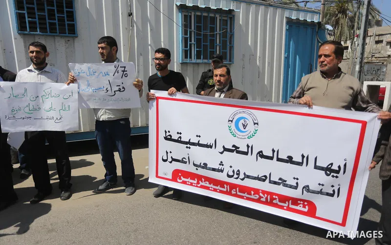 Union of the Palestinian syndicates members hold banners during a protest against Israeli blockade, in Gaza city, on April 19, 2017. Photo by Mohammed Asad
