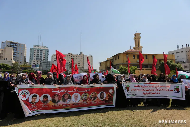Palestinian supporters of the Democratic Front for the Liberation of Palestine (DFLP), hold banners during a protest to show solidarity with Palestinian prisoners on hunger strike in Israeli jails, in Gaza city on April...