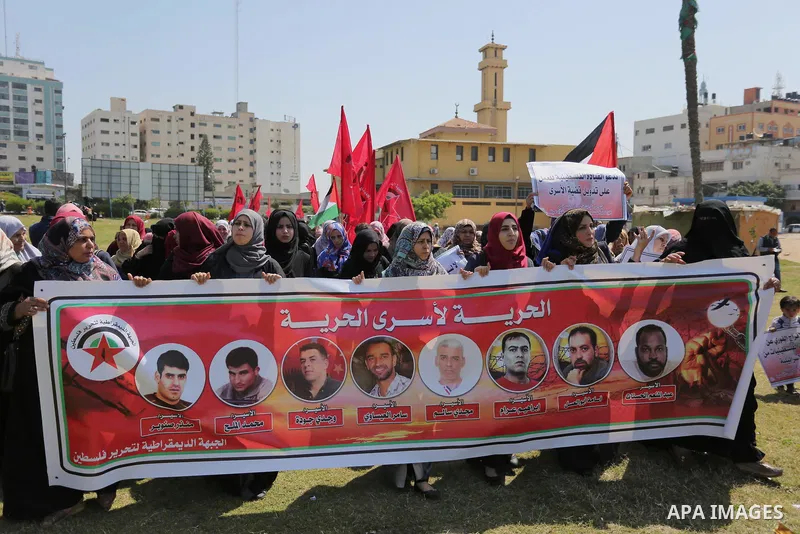 Palestinian supporters of the Democratic Front for the Liberation of Palestine (DFLP), hold banners during a protest to show solidarity with Palestinian prisoners on hunger strike in Israeli jails, in Gaza city on April...