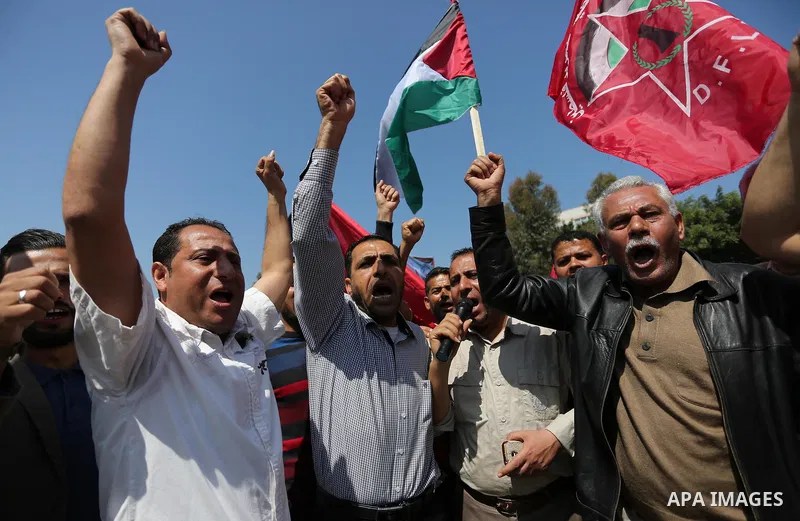 Palestinian supporters of the Democratic Front for the Liberation of Palestine (DFLP), hold banners during a protest to show solidarity with Palestinian prisoners on hunger strike in Israeli jails, in Gaza city on April...