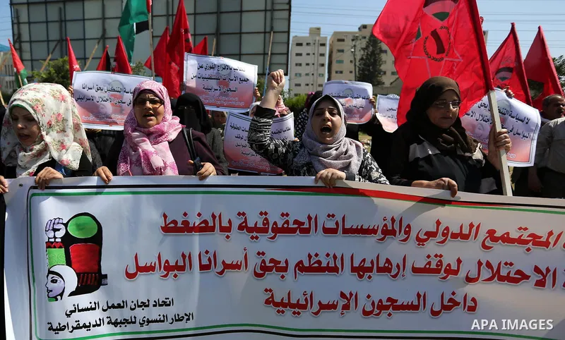 Palestinian supporters of the Democratic Front for the Liberation of Palestine (DFLP), hold banners during a protest to show solidarity with Palestinian prisoners on hunger strike in Israeli jails, in Gaza city on April...