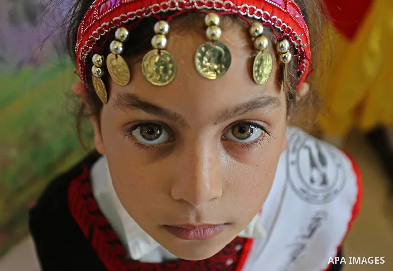 A Palestinian girl wears heritage as she poses for a photograph during a ceremony, in Gaza City April 20, 2017. Photo by Ashraf Amra