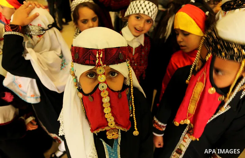 Palestinian girls wear heritage as they pose for a photograph during a ceremony, in Gaza City April 20, 2017. Photo by Ashraf Amra