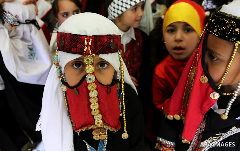 Palestinian girls wear heritage as they pose for a photograph during a ceremony, in Gaza City April 20, 2017. Photo by Ashraf Amra