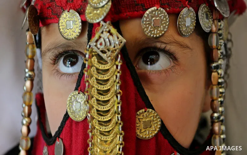 A Palestinian girl wears heritage as she poses for a photograph during a ceremony, in Gaza City April 20, 2017. Photo by Ashraf Amra