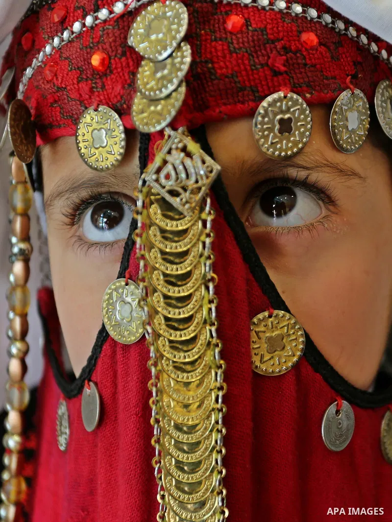 A Palestinian girl wears heritage as she poses for a photograph during a ceremony, in Gaza City April 20, 2017. Photo by Ashraf Amra