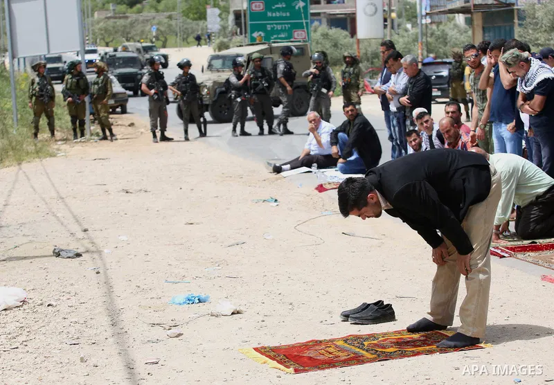 Palestinians demonstrators preform Friday prayers in the West Bank village of Beita, southeast of Nablus city, prior to a demonstration in solidarity with Palestinian prisoners on hunger strike in Israeli jails, on April...