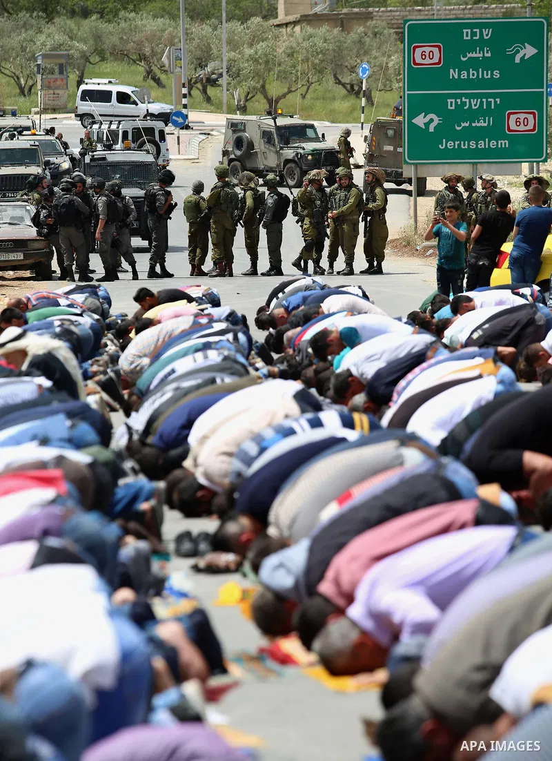 Palestinians demonstrators preform Friday prayers in the West Bank village of Beita, southeast of Nablus city, prior to a demonstration in solidarity with Palestinian prisoners on hunger strike in Israeli jails, on April...