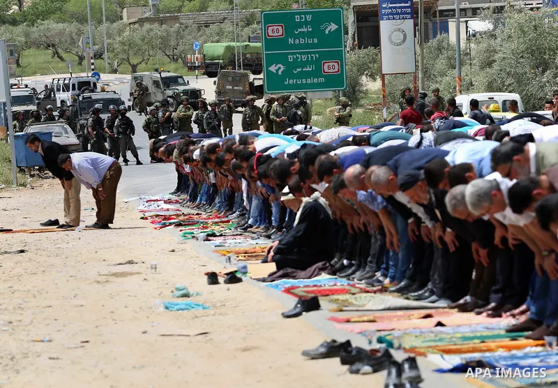 Palestinians demonstrators preform Friday prayers in the West Bank village of Beita, southeast of Nablus city, prior to a demonstration in solidarity with Palestinian prisoners on hunger strike in Israeli jails, on April...