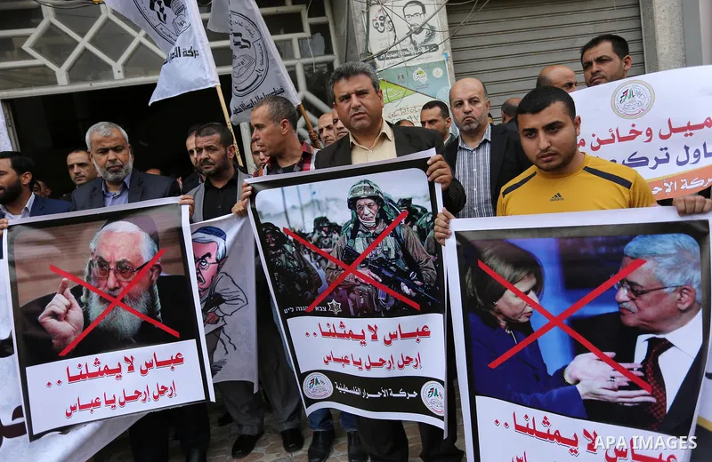 Palestinian supporters of Al-Ahrar movement hold banners during a protest against Palestinian President Mahmoud Abbas and Israeli blockade of the Gaza Strip, in Gaza city, on April 22, 2017. Photo by Ashraf Amra
