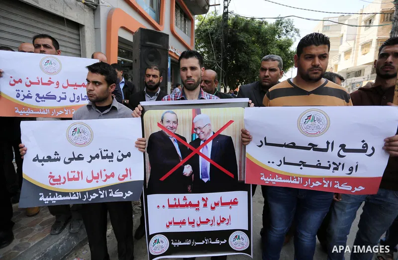 Palestinian supporters of Al-Ahrar movement hold banners during a protest against Palestinian President Mahmoud Abbas and Israeli blockade of the Gaza Strip, in Gaza city, on April 22, 2017. Photo by Ashraf Amra