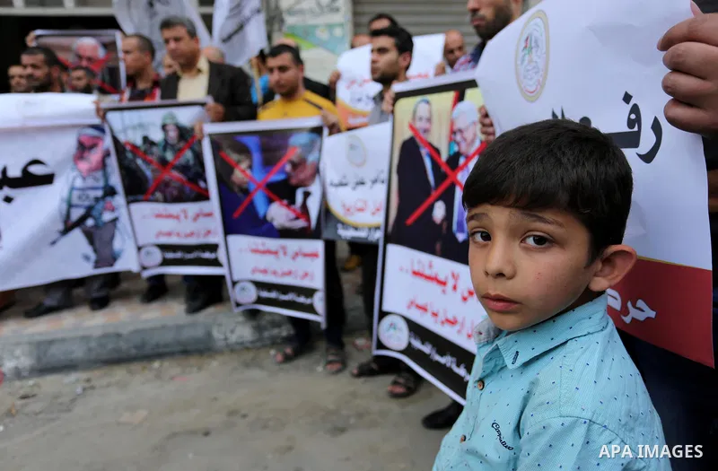 Palestinian supporters of Al-Ahrar movement hold banners during a protest against Palestinian President Mahmoud Abbas and Israeli blockade of the Gaza Strip, in Gaza city, on April 22, 2017. Photo by Ashraf Amra