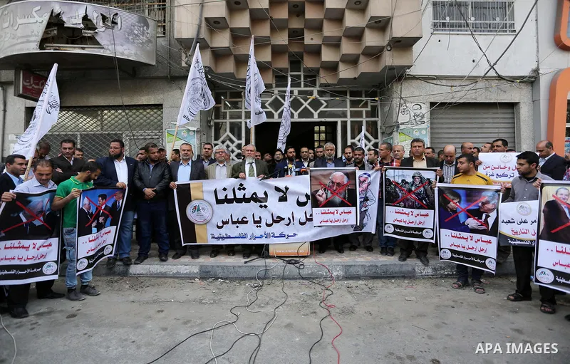 Palestinian supporters of Al-Ahrar movement hold banners during a protest against Palestinian President Mahmoud Abbas and Israeli blockade of the Gaza Strip, in Gaza city, on April 22, 2017. Photo by Ashraf Amra