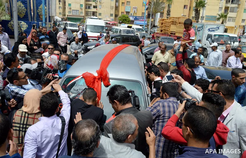 Egypians stand next to a mini-bus before Mona El Sayed, an Egyptian woman known in media as "girl cart" receives it which was funded by “Tahya Masr” (Long Live Egypt) fund in Cairo, Egypt, on April 22, 2017. Just days af...