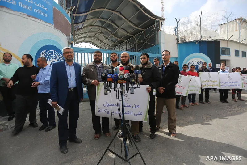Palestinians hold banners during a protest to demand UNRWA provide electricity to refugee camps, in Gaza city, on April 23, 2017. Photo by Mohammed Asad