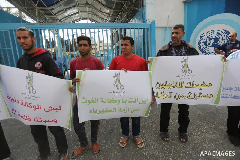 Palestinians hold banners during a protest to demand UNRWA provide electricity to refugee camps, in Gaza city, on April 23, 2017. Photo by Mohammed Asad