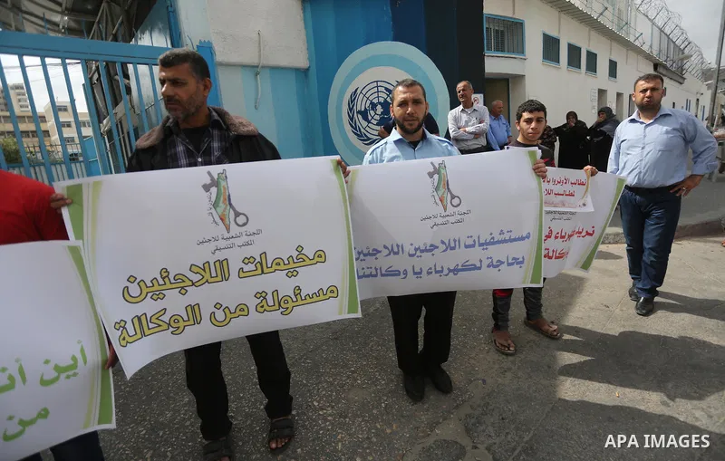 Palestinians hold banners during a protest to demand UNRWA provide electricity to refugee camps, in Gaza city, on April 23, 2017. Photo by Mohammed Asad