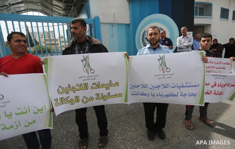 Palestinians hold banners during a protest to demand UNRWA provide electricity to refugee camps, in Gaza city, on April 23, 2017. Photo by Mohammed Asad