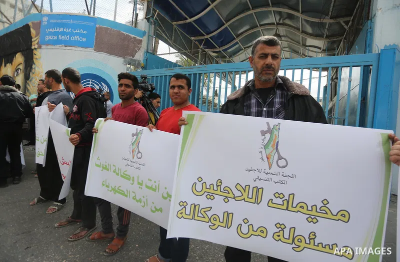 Palestinians hold banners during a protest to demand UNRWA provide electricity to refugee camps, in Gaza city, on April 23, 2017. Photo by Mohammed Asad